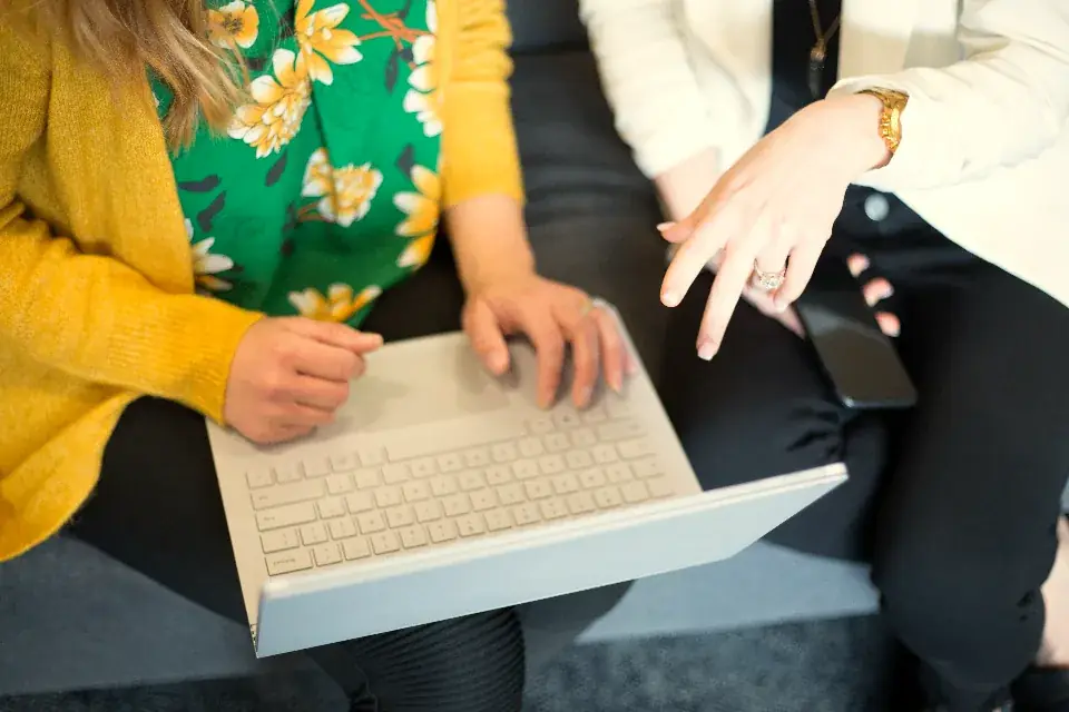 Two colleagues reviewing insurance cover together on a laptop