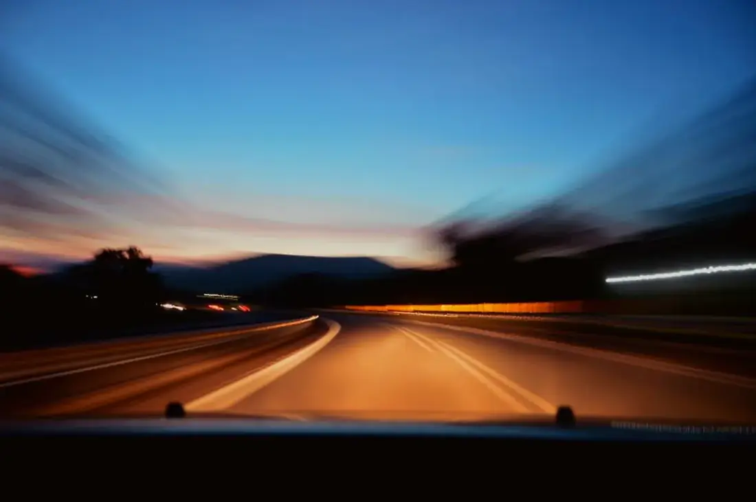 A car on an open road at dusk, protected by comprehensive motor cover